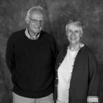 A man and a woman are standing next to each other in a black and white photo.