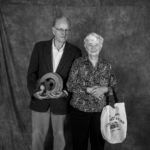 A man and a woman are standing next to each other in a black and white photo.