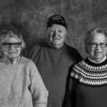 Three older people are posing for a black and white photo.