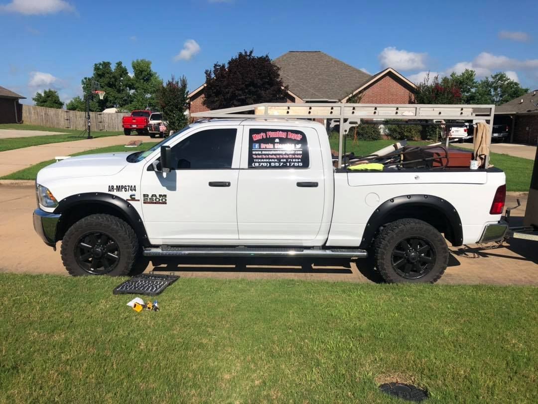 White pickup truck parked on a lawn in front of a house on a sunny day