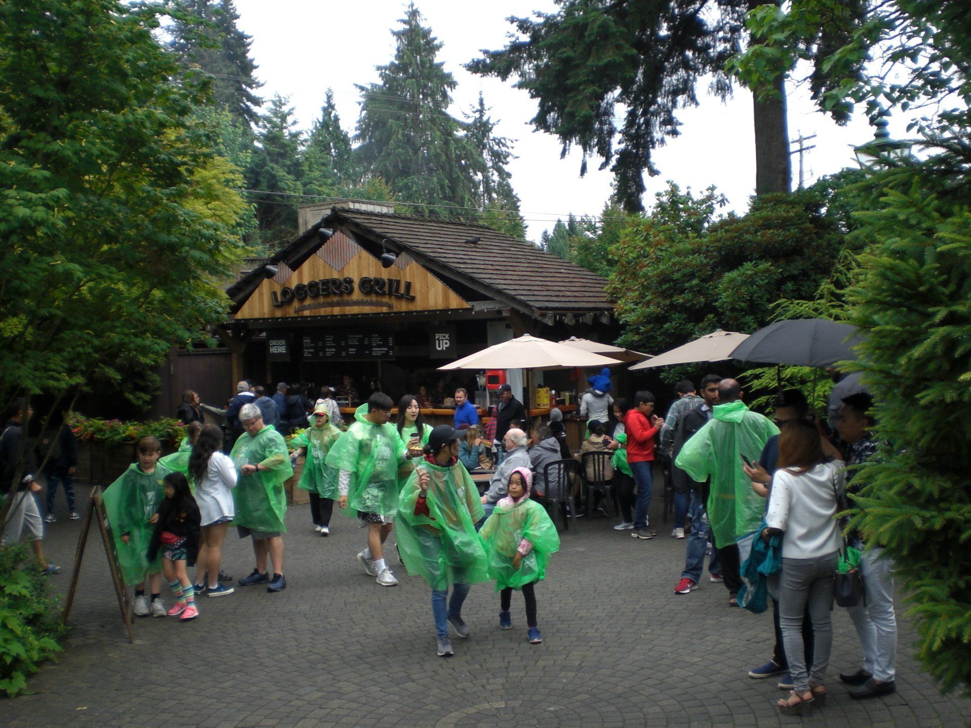 People in green raincoats in front of a 