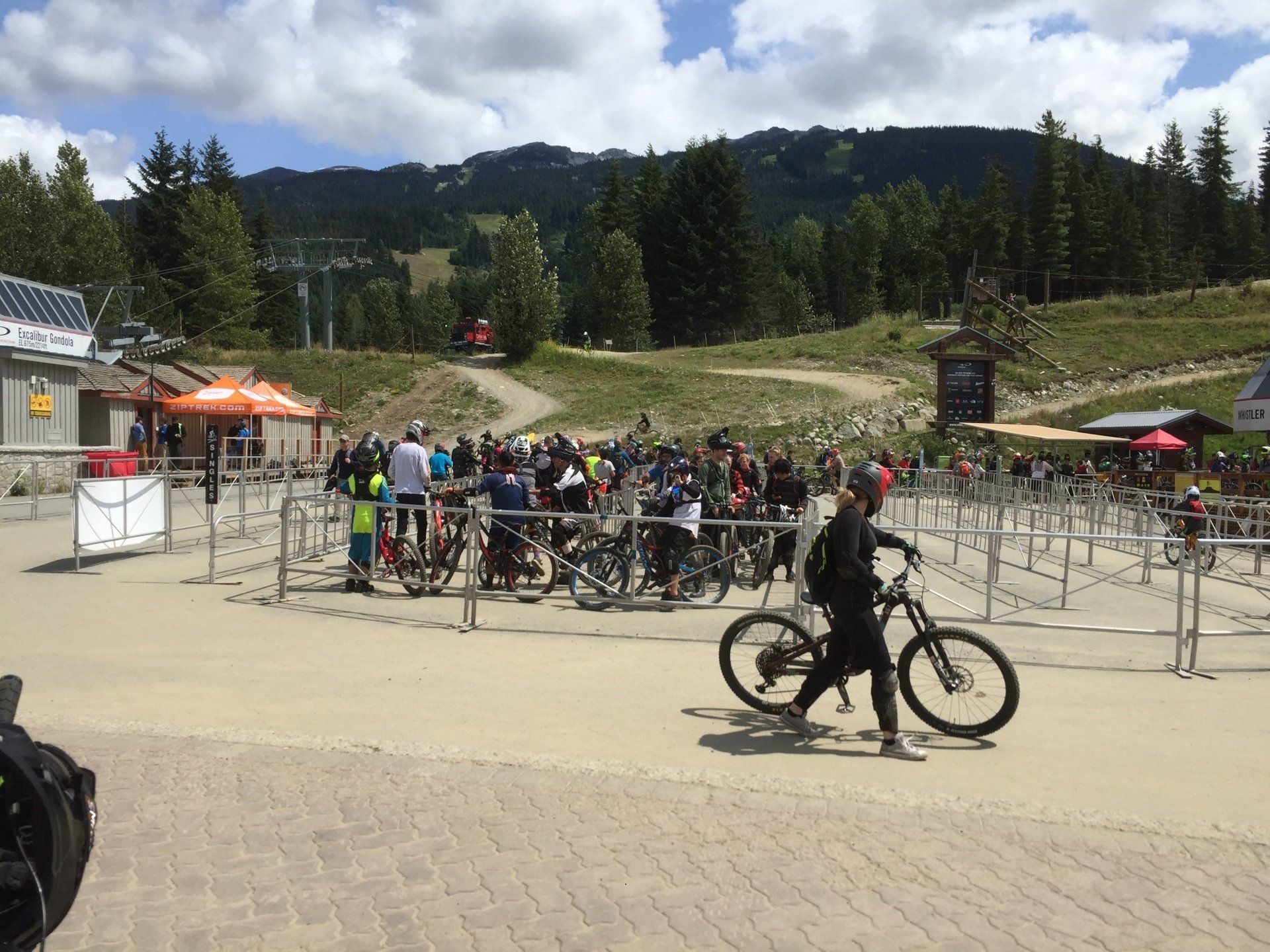 People and bikes at a bike park, with a lift in the background.