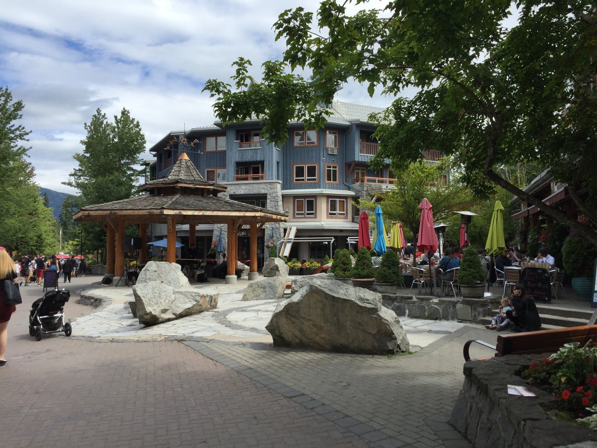 Courtyard in Whistler Village, BC, with gazebo, large rocks, restaurants, and people.