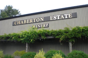 Chaberton Estate Winery sign on a building with green vines.