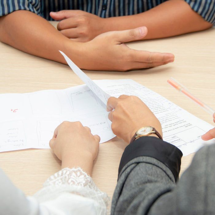 A person wearing a watch is looking at a piece of paper