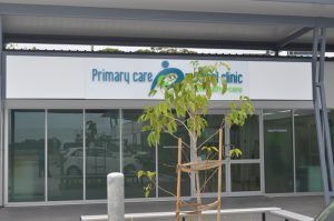 The front of a primary care clinic with a tree in front of it.