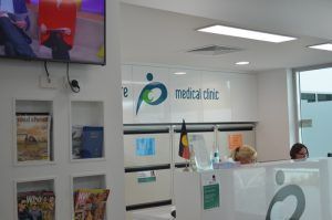 A woman is sitting at a counter in a medical clinic.