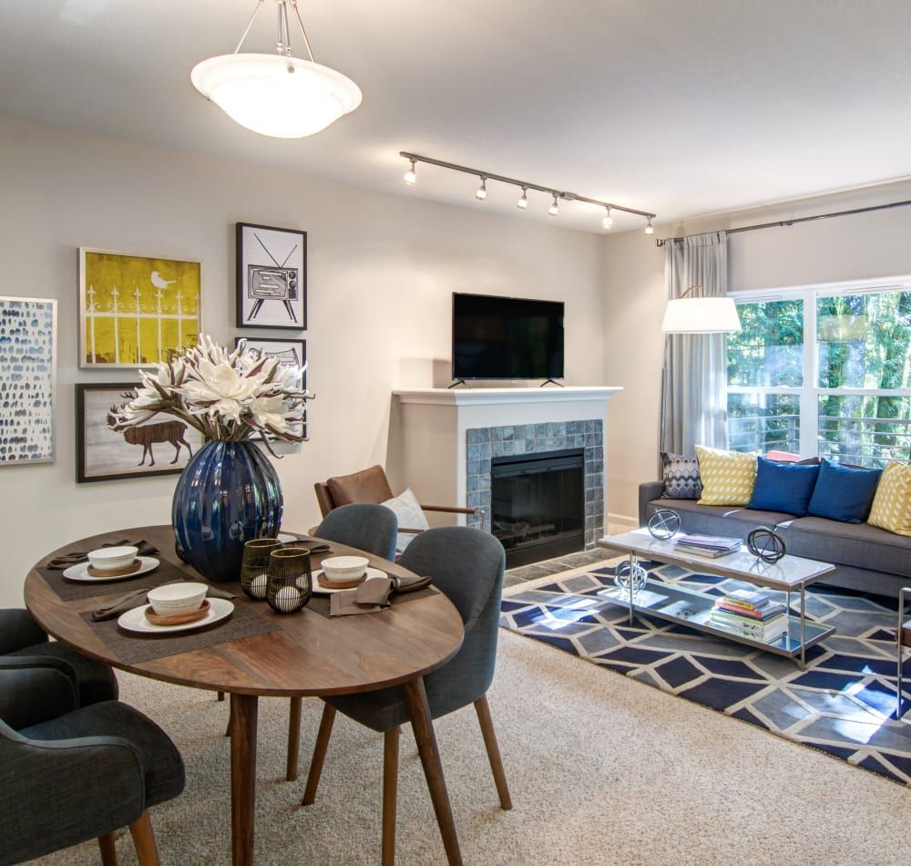 Dining and living room with a table, sofa, fireplace, and wall art.