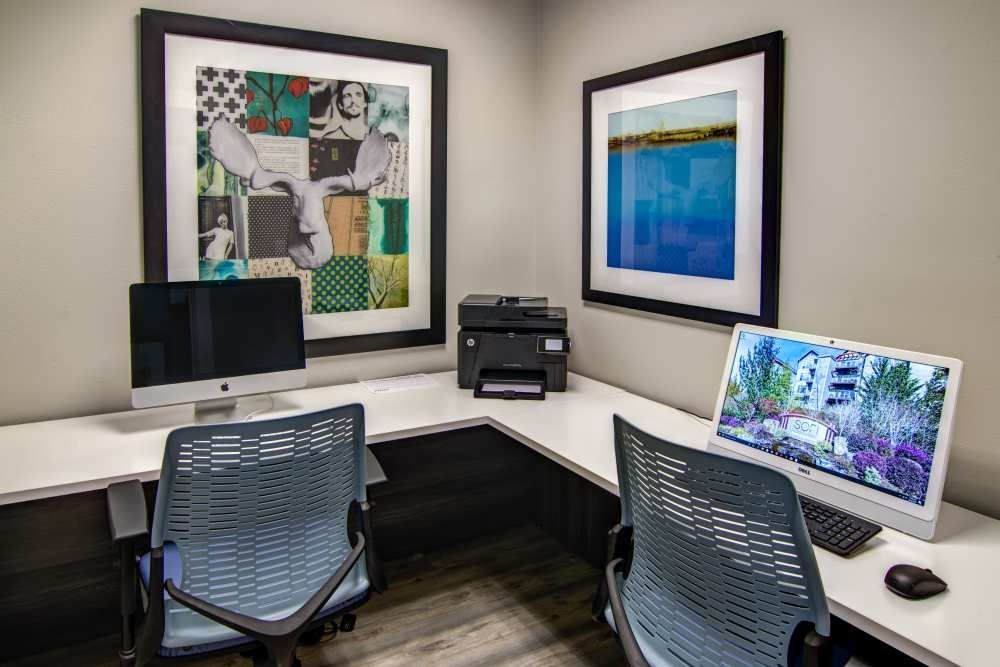 L-shaped office space with two computers, printer, and abstract art on walls at Sofi at Forest Heights, offers apartments for rent in Portland, OR.