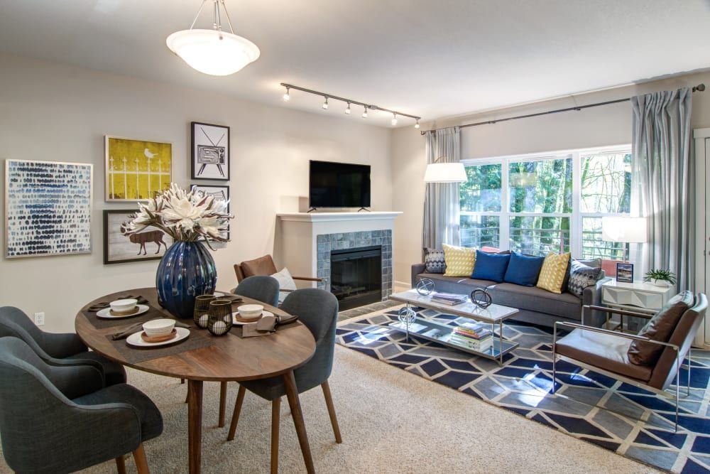 Dining and living area with art, fireplace, and gray and blue decor at Sofi at Forest Heights, offers apartments for rent in Portland, OR.