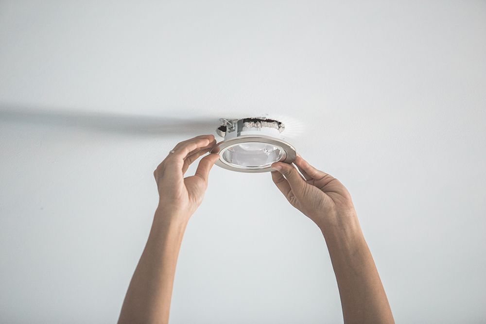 electrician installing lighting fixture