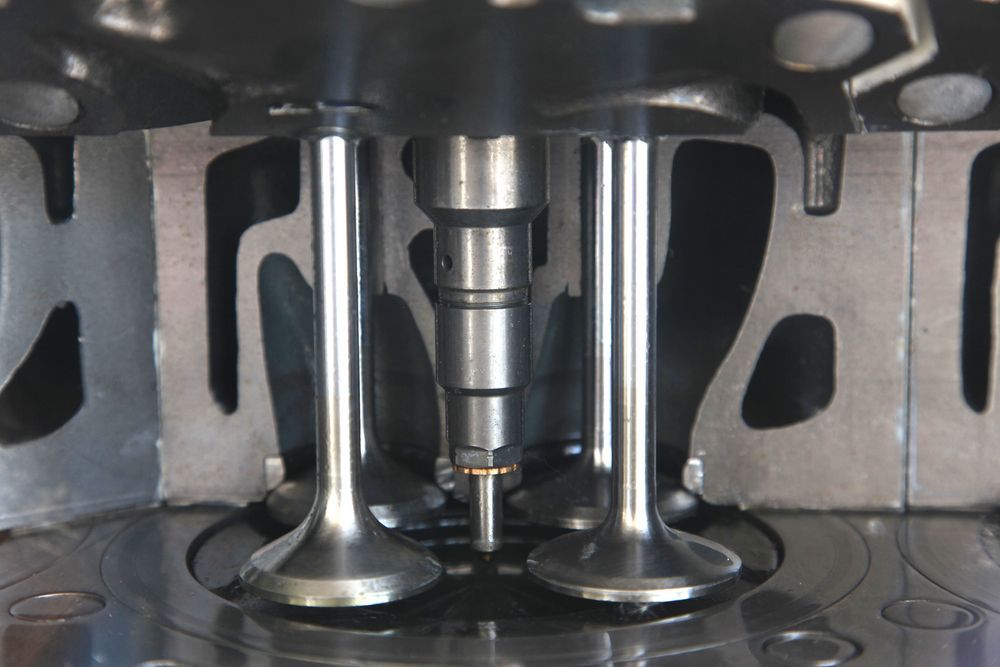 Primer plano de las válvulas y pistones del motor dentro de una culata.
