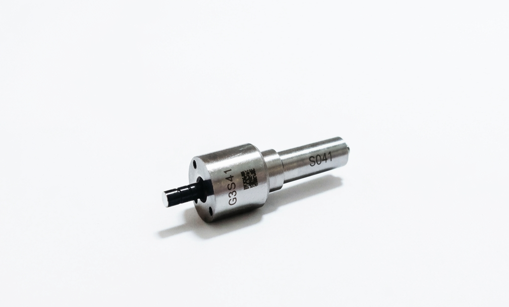 Conector pequeño de metal plateado con punta negra sobre fondo blanco