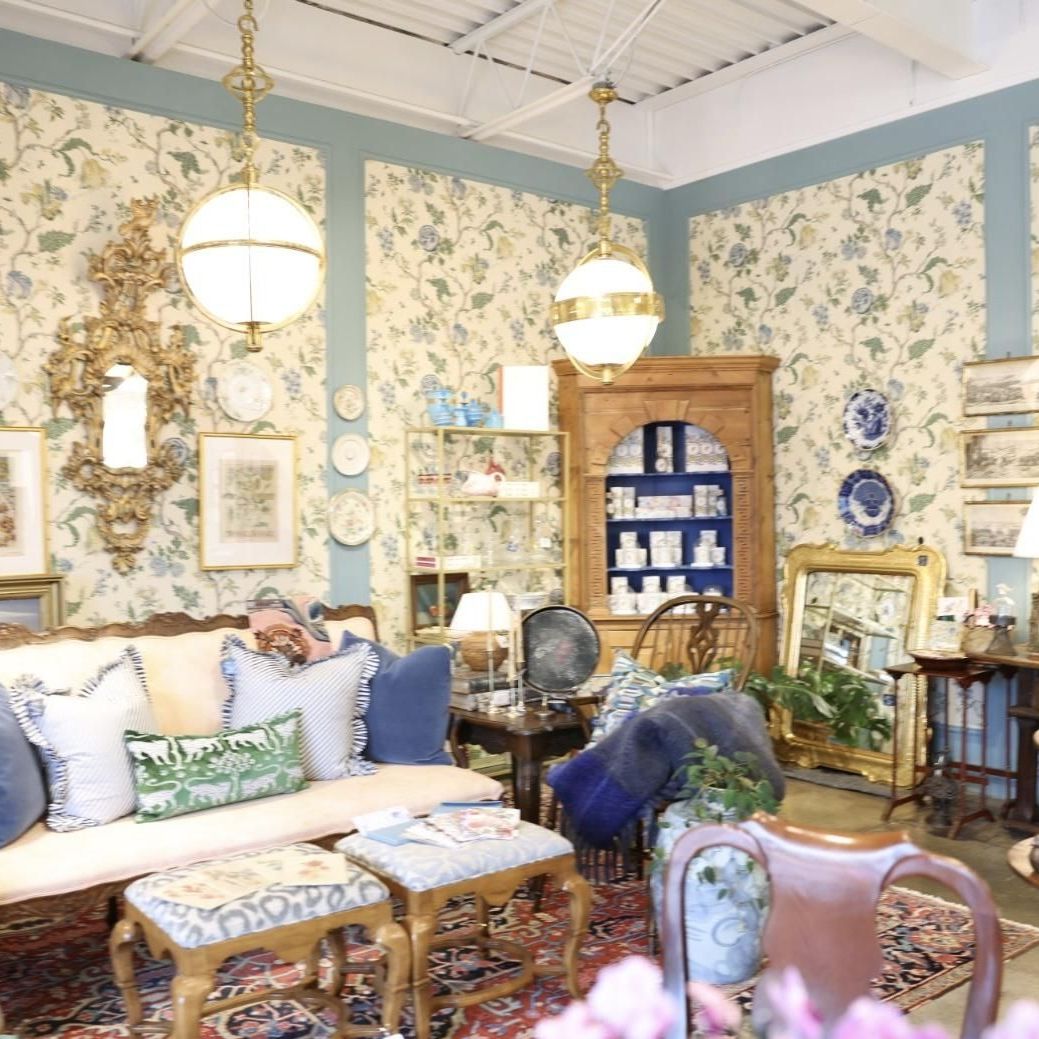 Vintage-style living room with floral wallpaper, gold mirror, and custom shelving – interior home improvements.