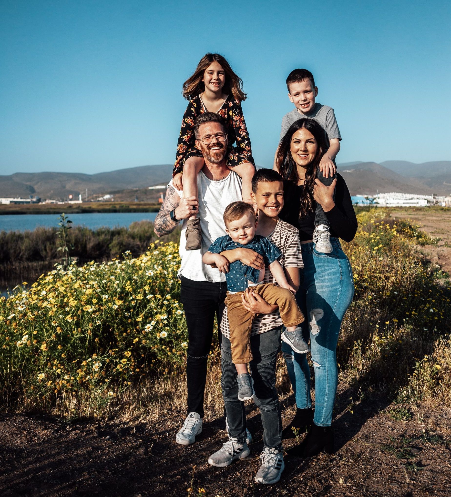 A family is posing for a picture in a field.