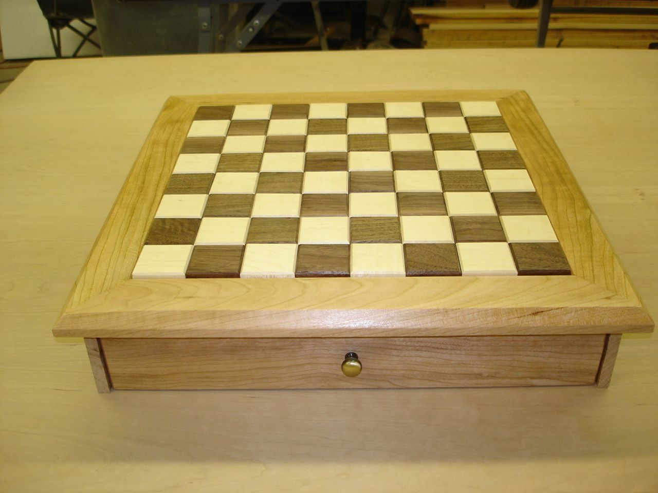A wooden chessboard with a drawer.