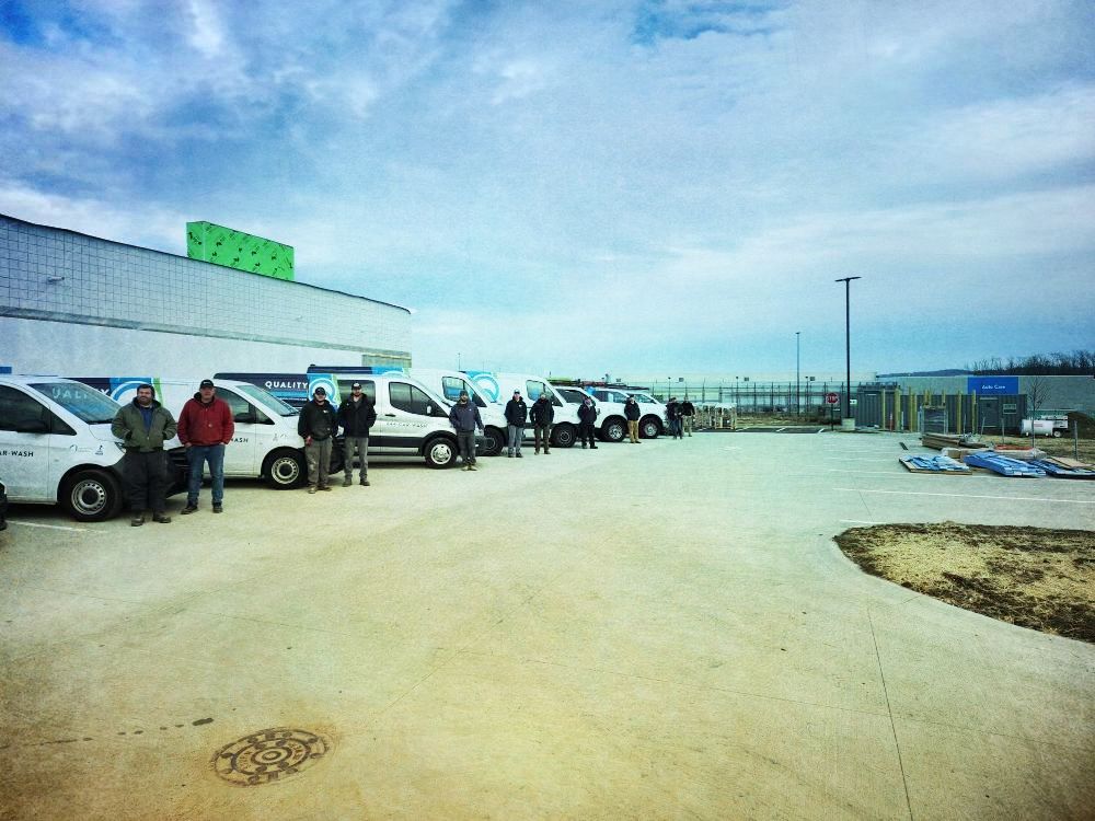 A group of people standing in front of a row of white vans.