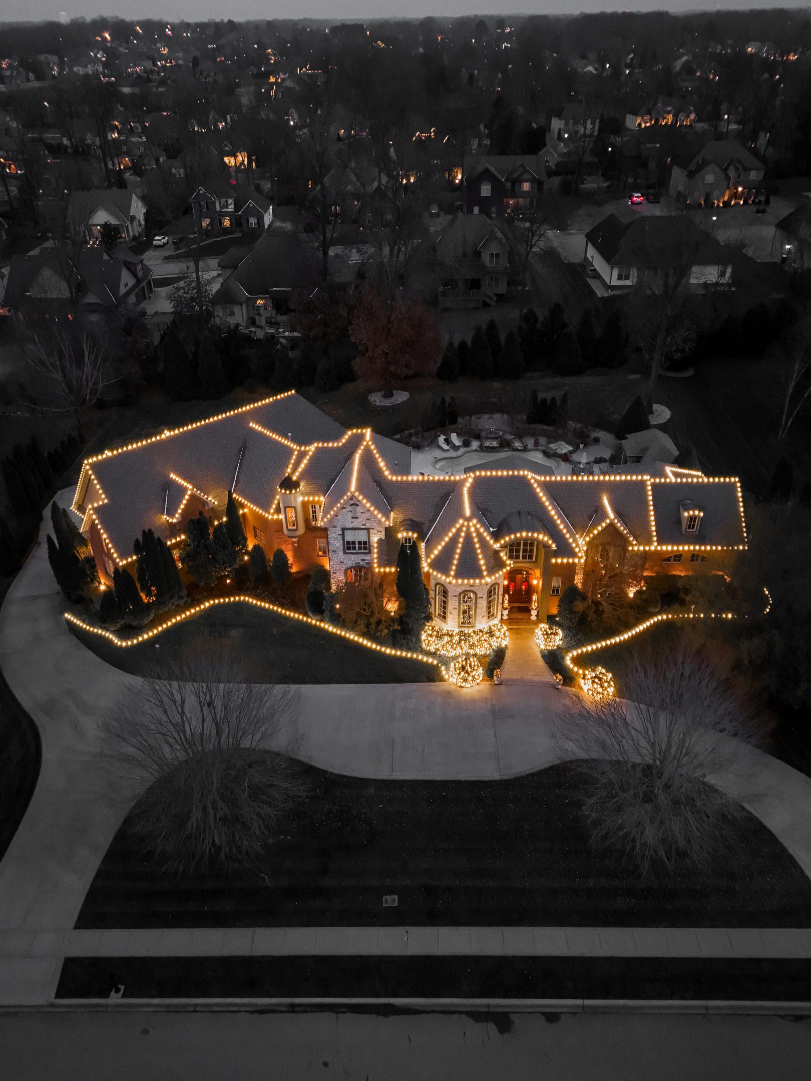 A large house is lit up with christmas lights at night.