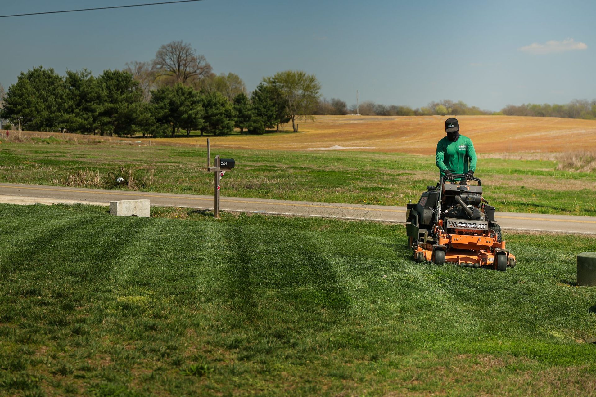 A lawn mower is cutting a lush green lawn.