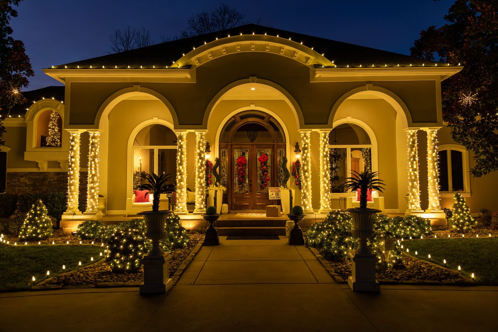 House decorated with yellow Christmas lights at dusk.