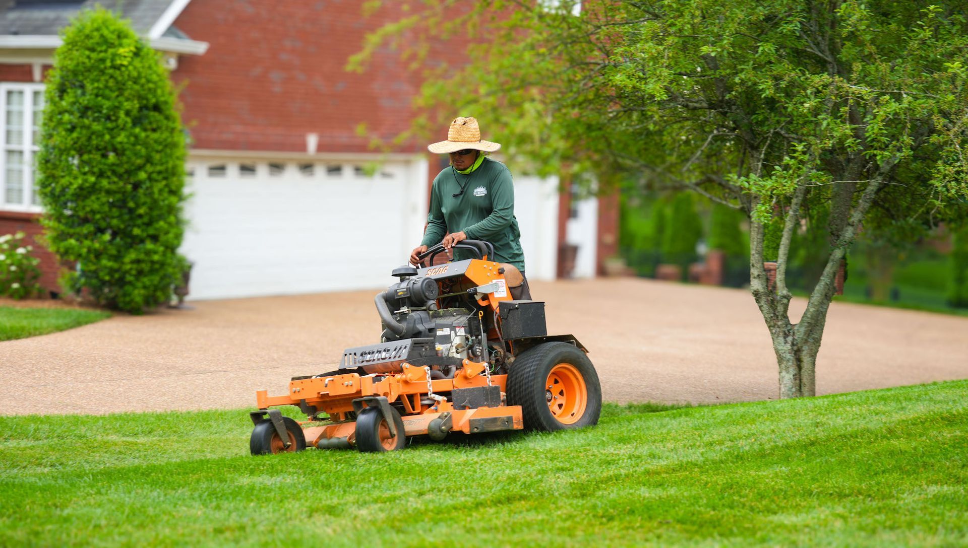 A man is riding a lawn mower on a lush green lawn.