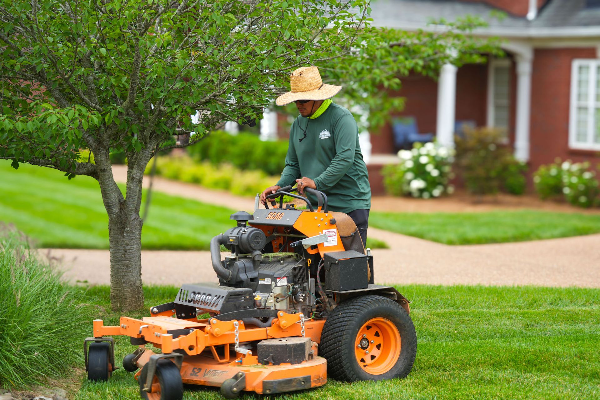 A man is riding a lawn mower on a lush green lawn.