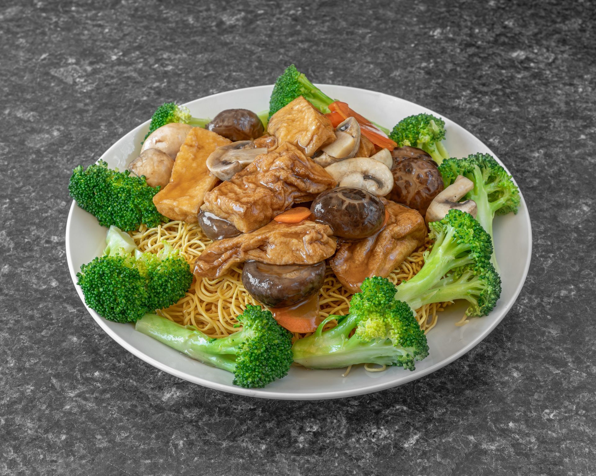 Plate of Chinese food: noodles, tofu, mushrooms, broccoli, and carrots.