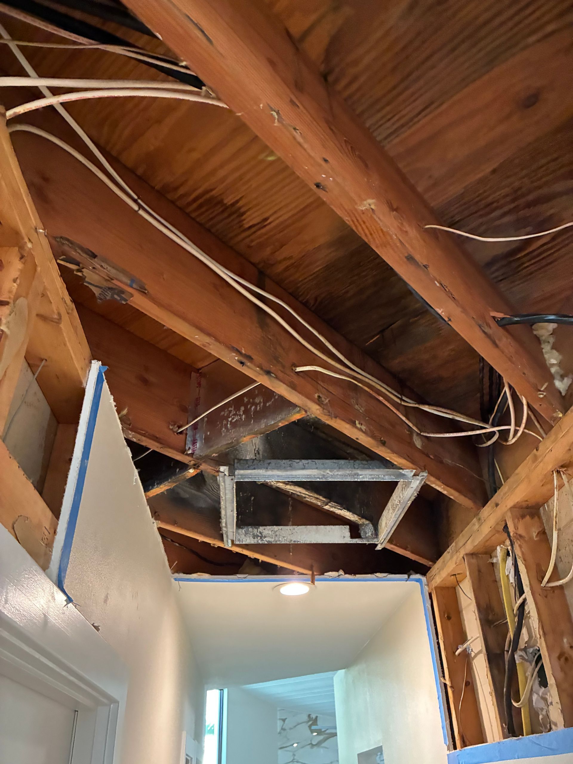 Ceiling and wall materials removed to expose water-damaged framing on Siesta Key