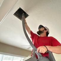 Acme Restoration technician inspecting a ceiling air vent in a Sarasota home