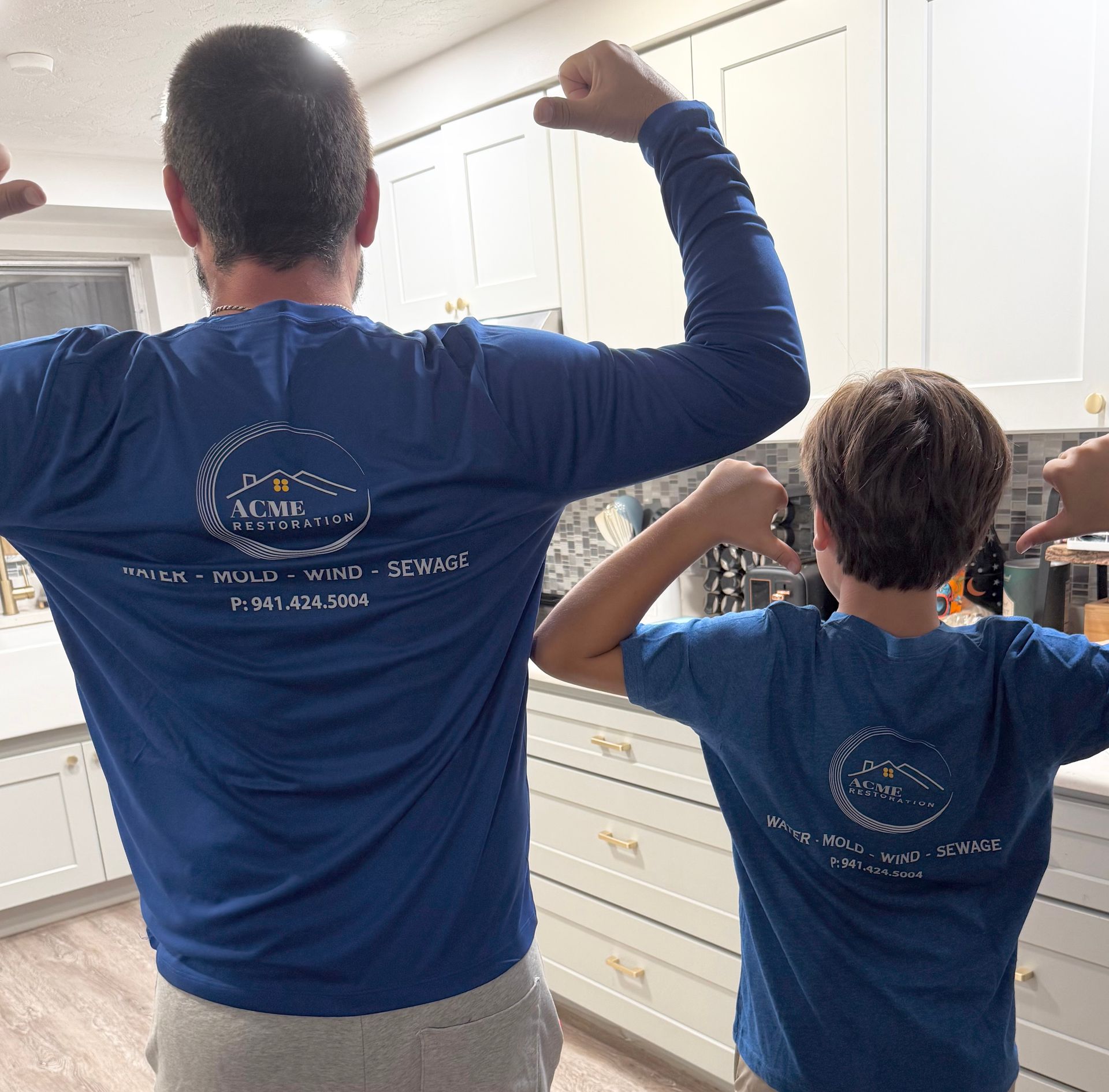 Chris and his son wearing Acme Cleaning & Restoration shirts and flexing together.