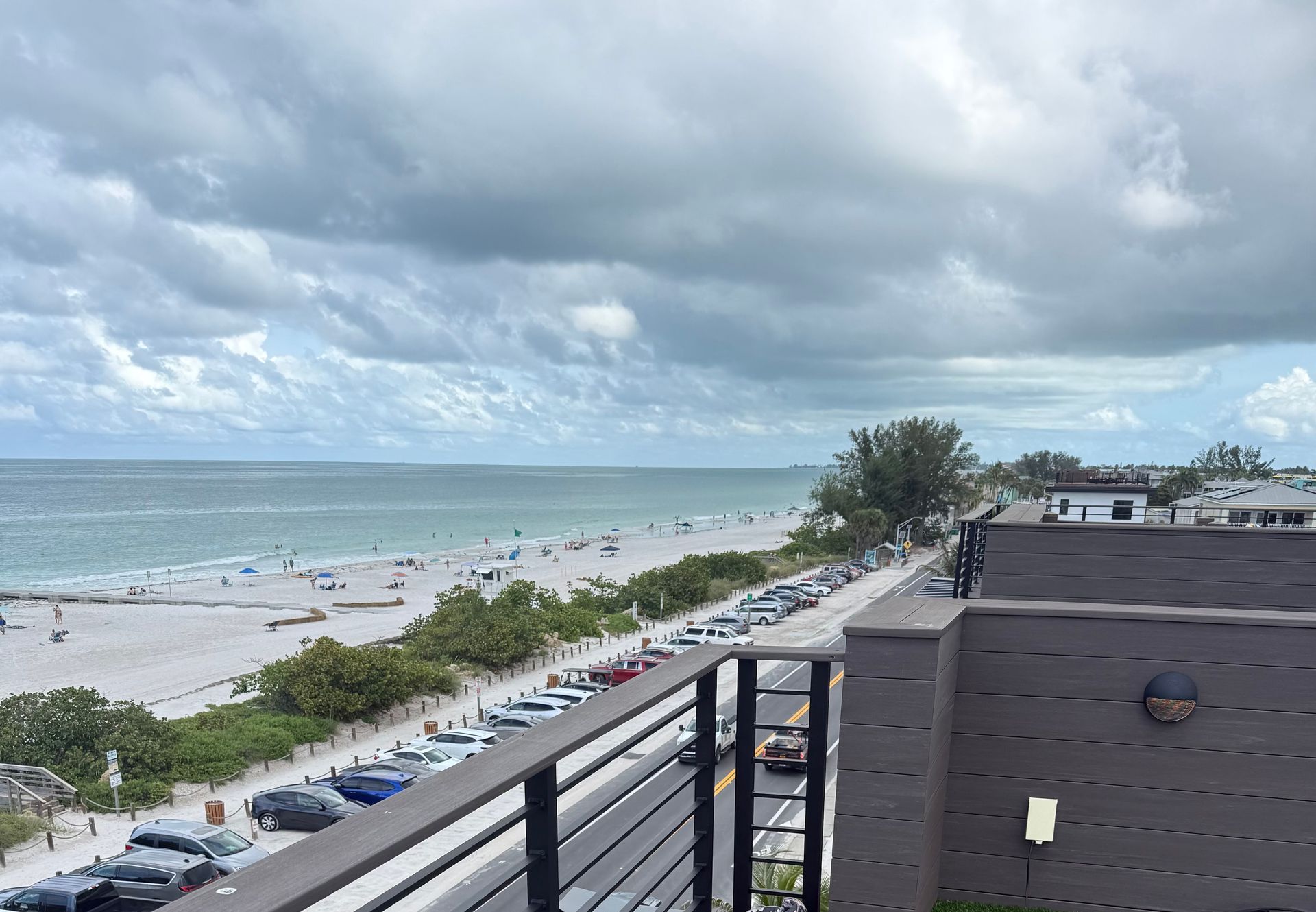 Dark storm clouds gathering over a Sarasota beach and the Gulf of Mexico, viewed from a rooftop.
