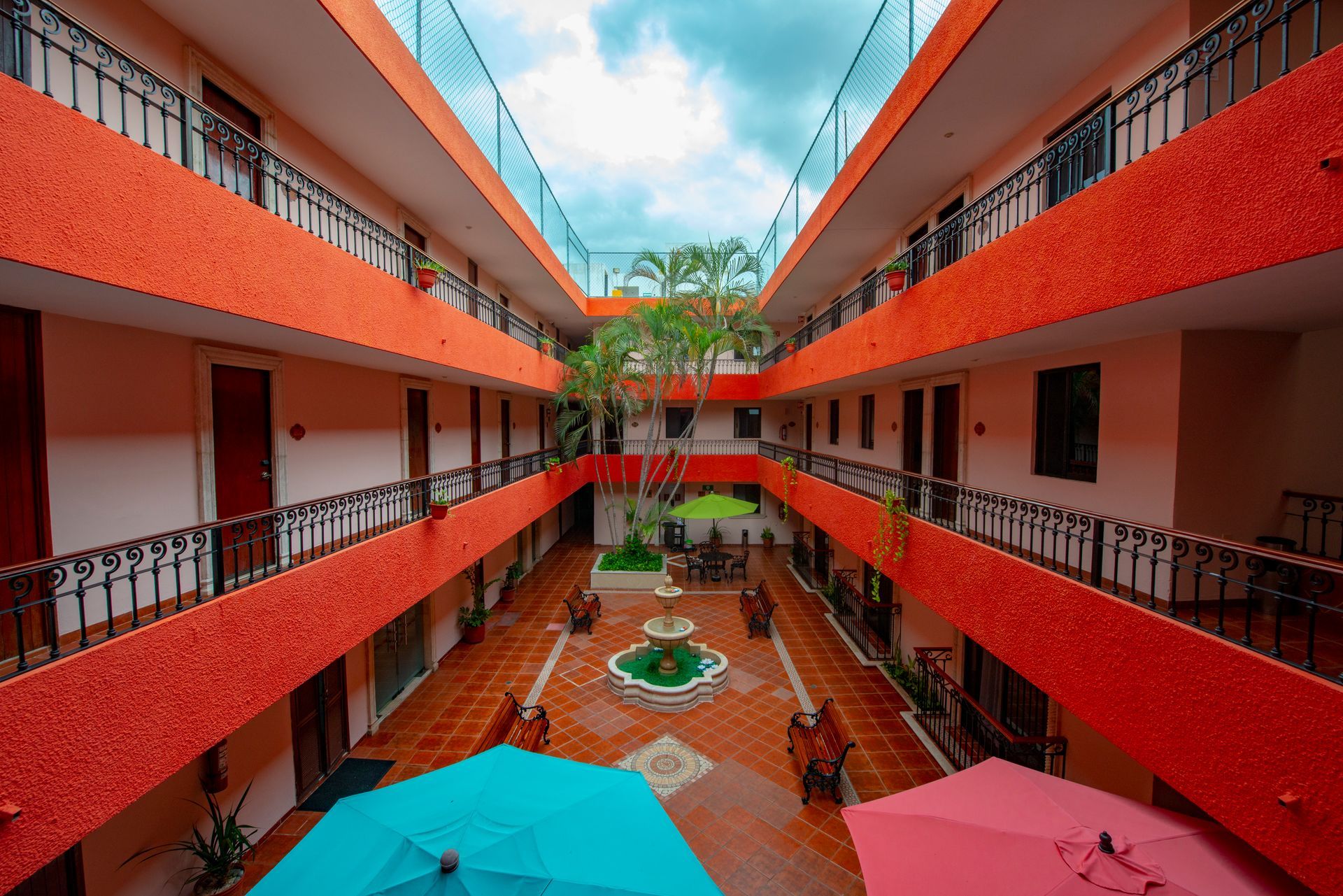 A hotel courtyard with a blue umbrella in the middle