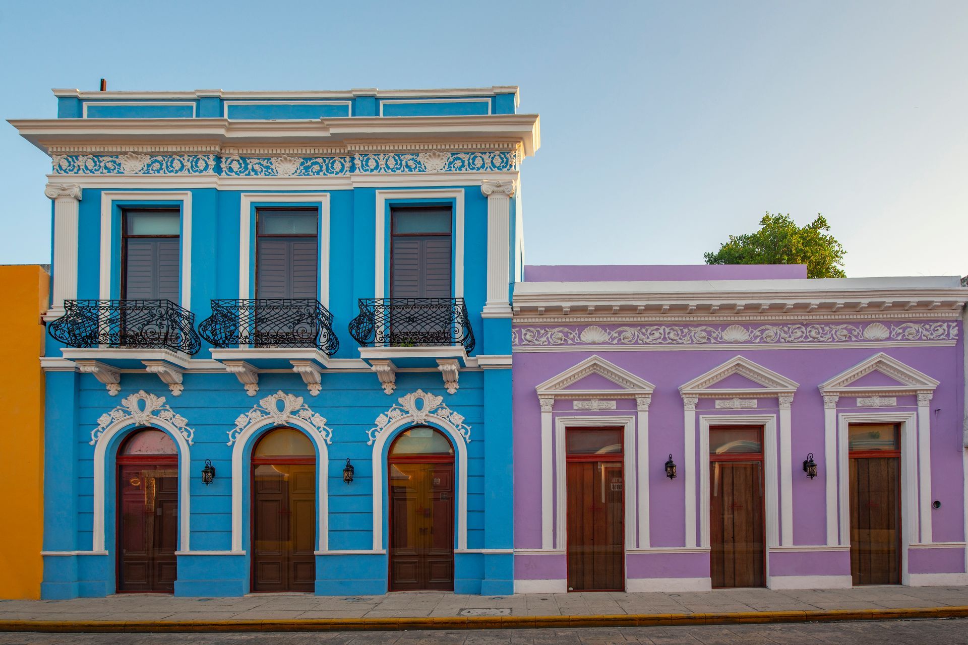 A blue and purple building are next to each other on a street.