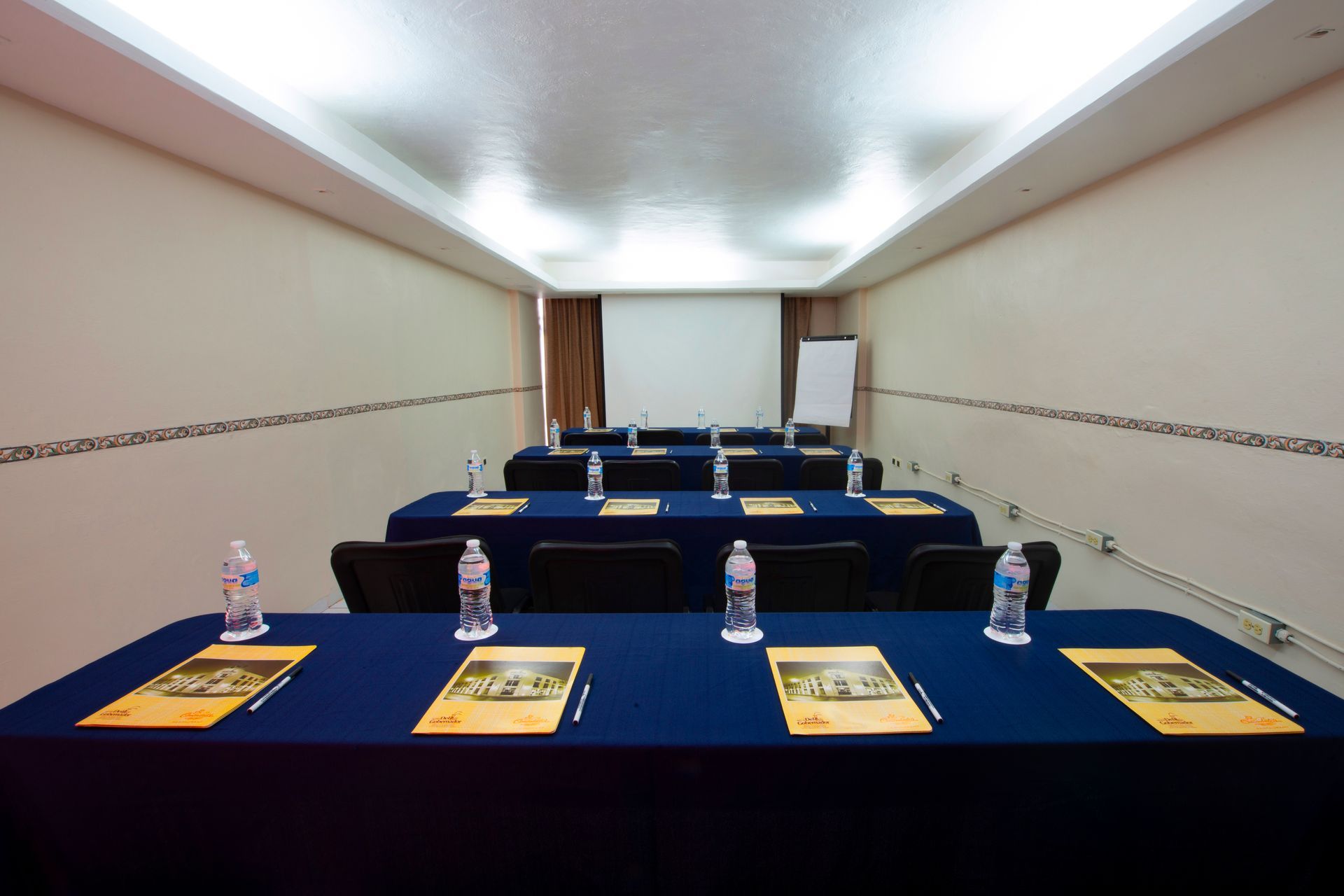 A conference room with tables and chairs set up for a meeting
