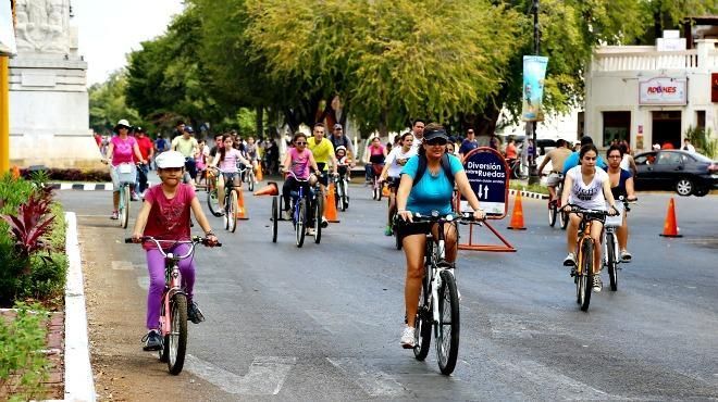 A group of people are riding bikes down a street