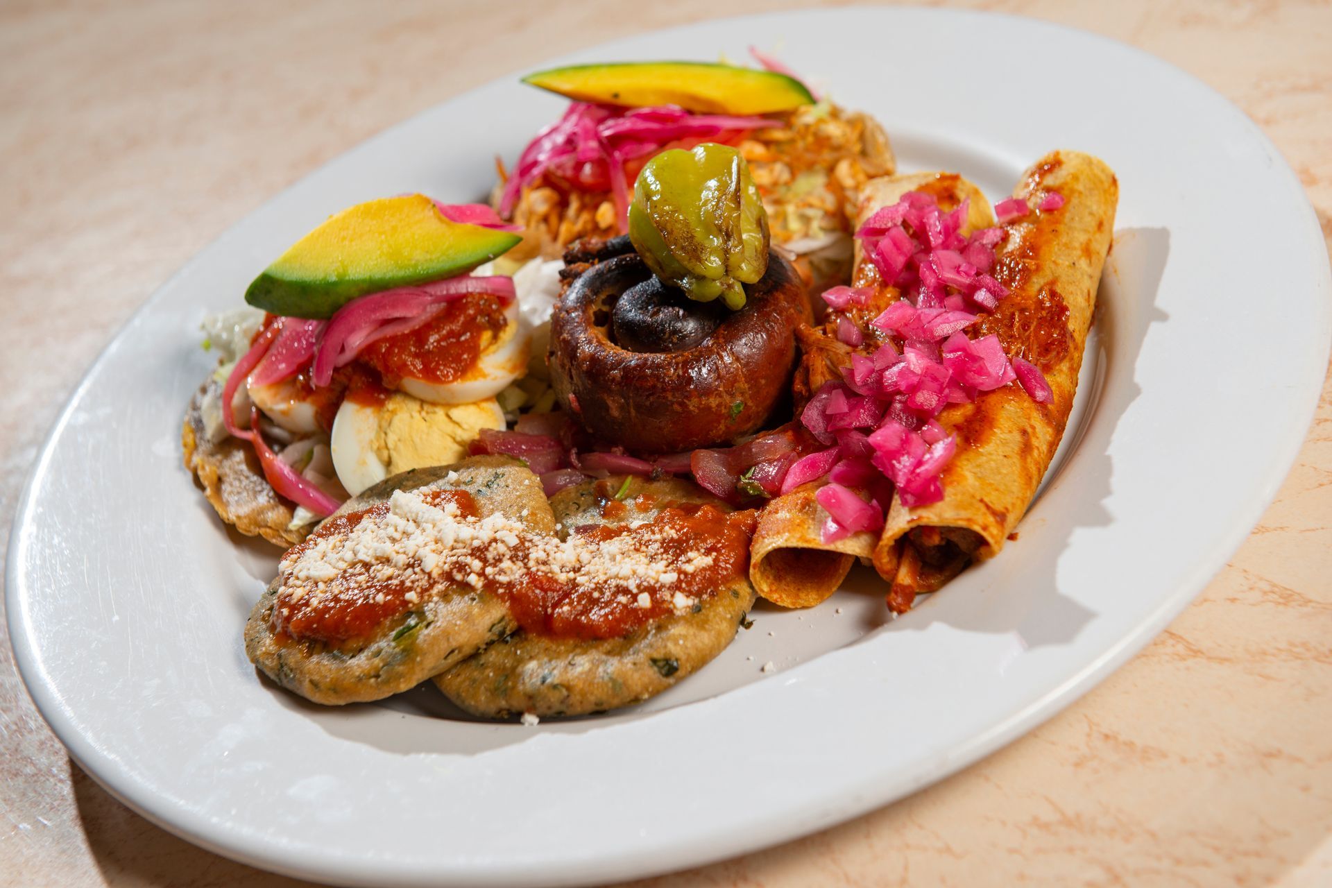 A white plate topped with a variety of food on a table.