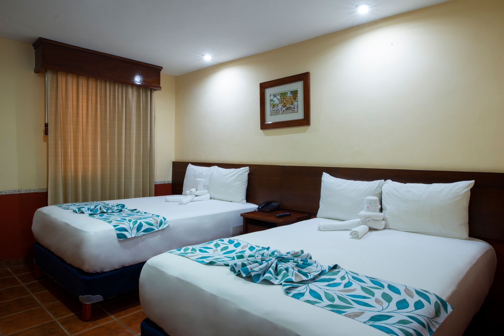 A hotel room with two beds and a window