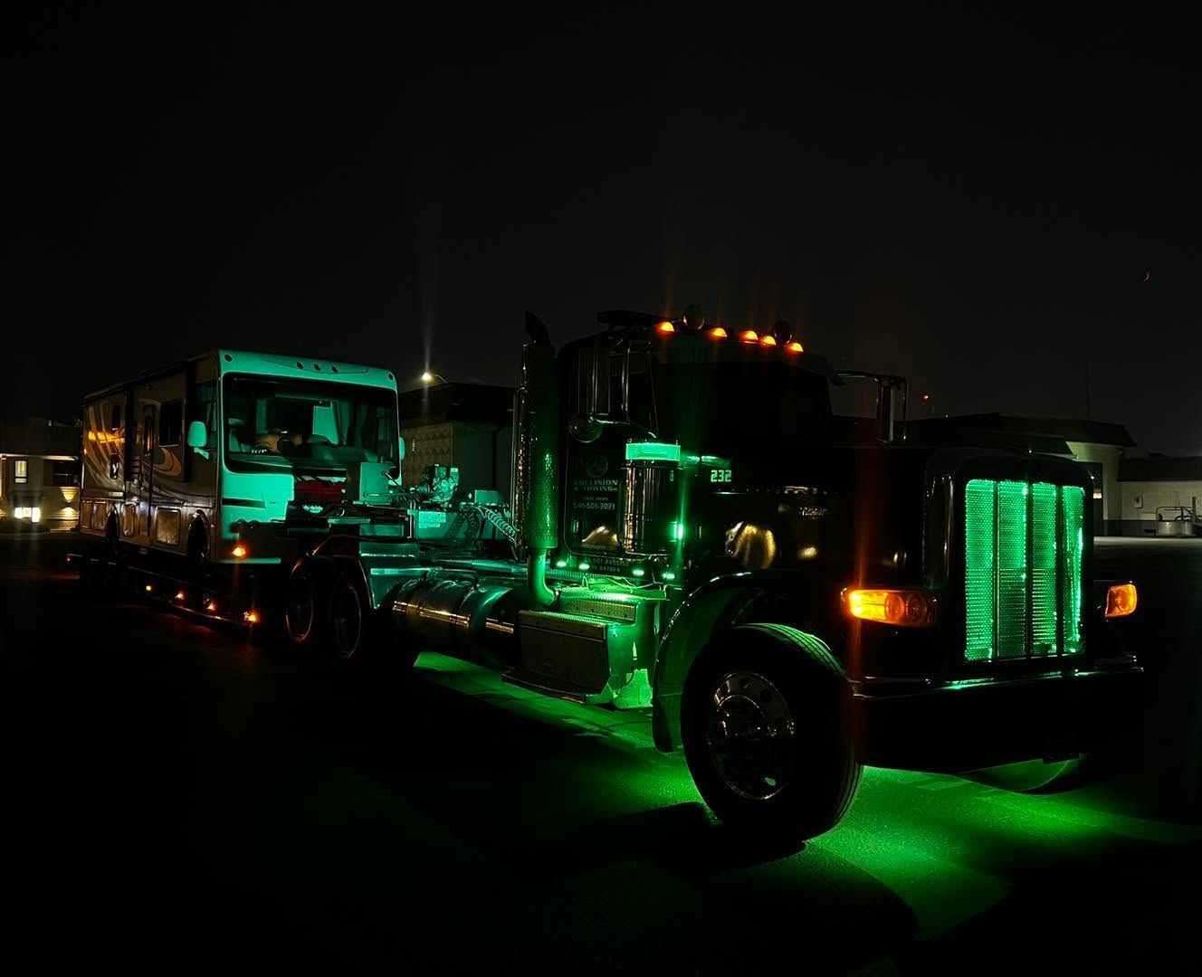 Green-lit custom trucks parked at night with glowing undercarriage lights