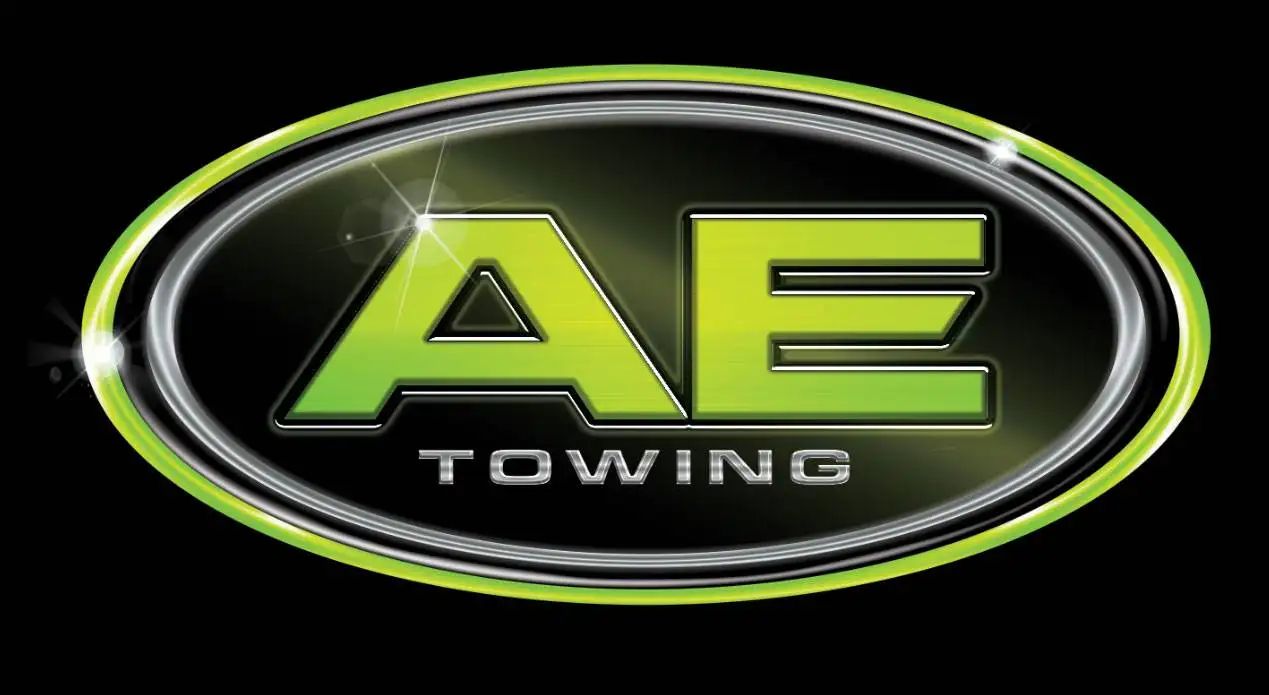 AE Towing logo with lime green &ldquo;AE&rdquo; on a black oval badge