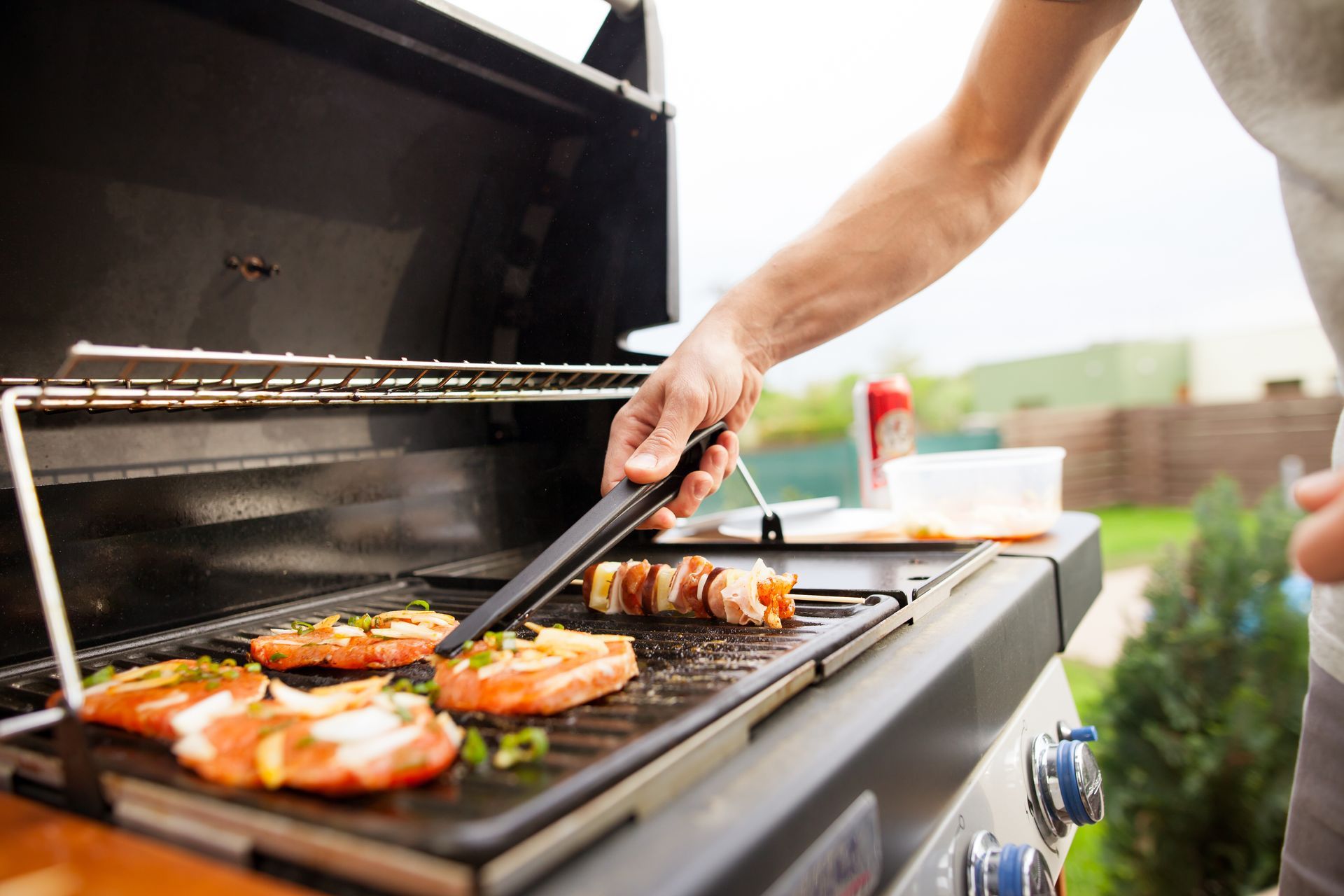 man cooking burger on the gas grill