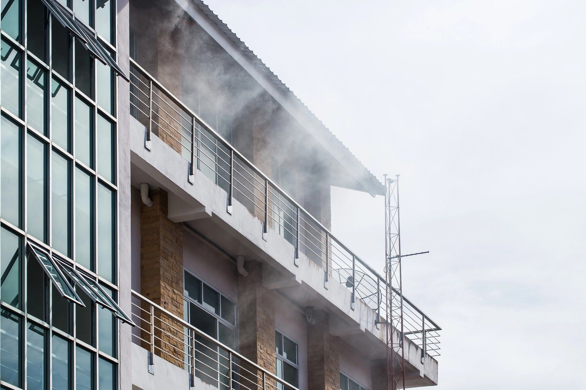 Bâtiment avec un système de désenfumage en action, évacuant les fumées d’un incendie pour assurer la