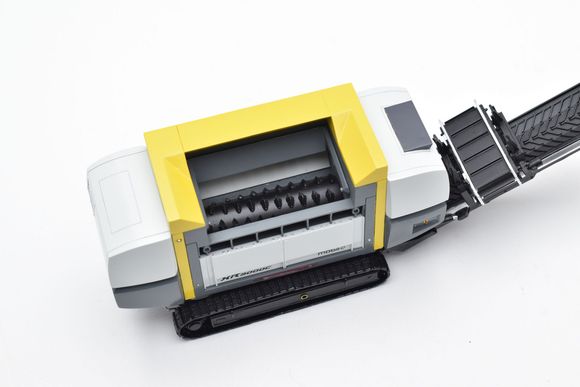 Mobiele recyclingmachine, wit en geel, met zwarte rupsband en transportband.