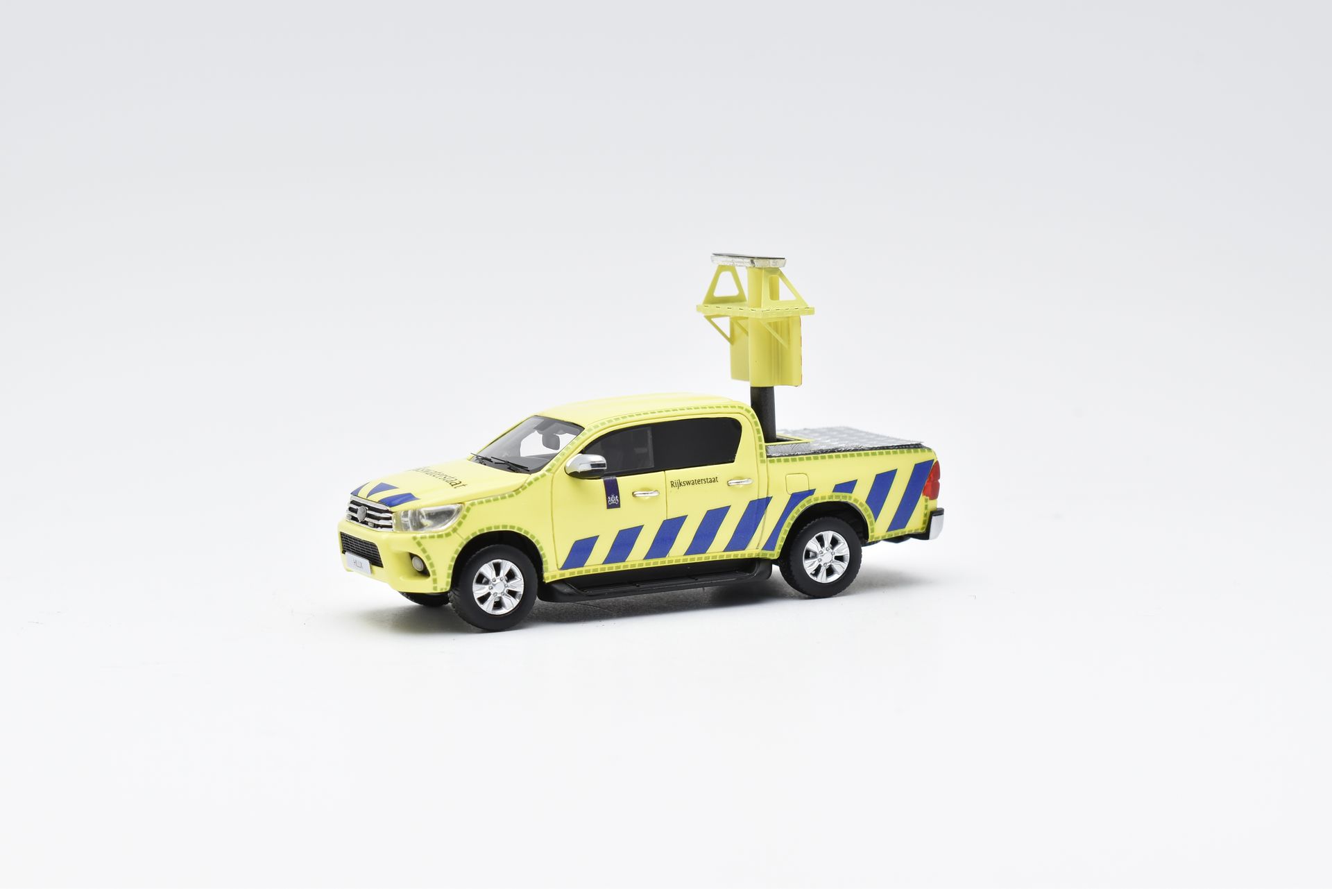 Gele pick-uptruck met blauwe diagonale strepen en een gemonteerde lamp, op een witte achtergrond.