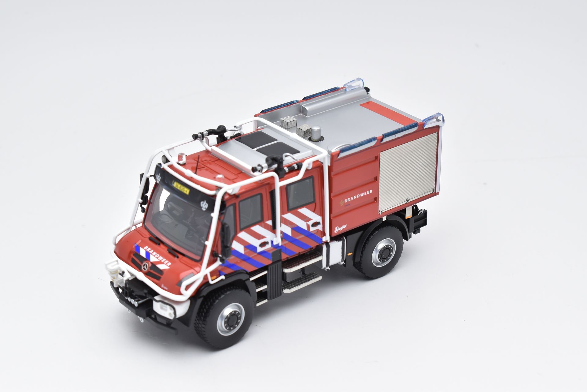 Rode en zilveren brandweerwagen op een wit oppervlak.