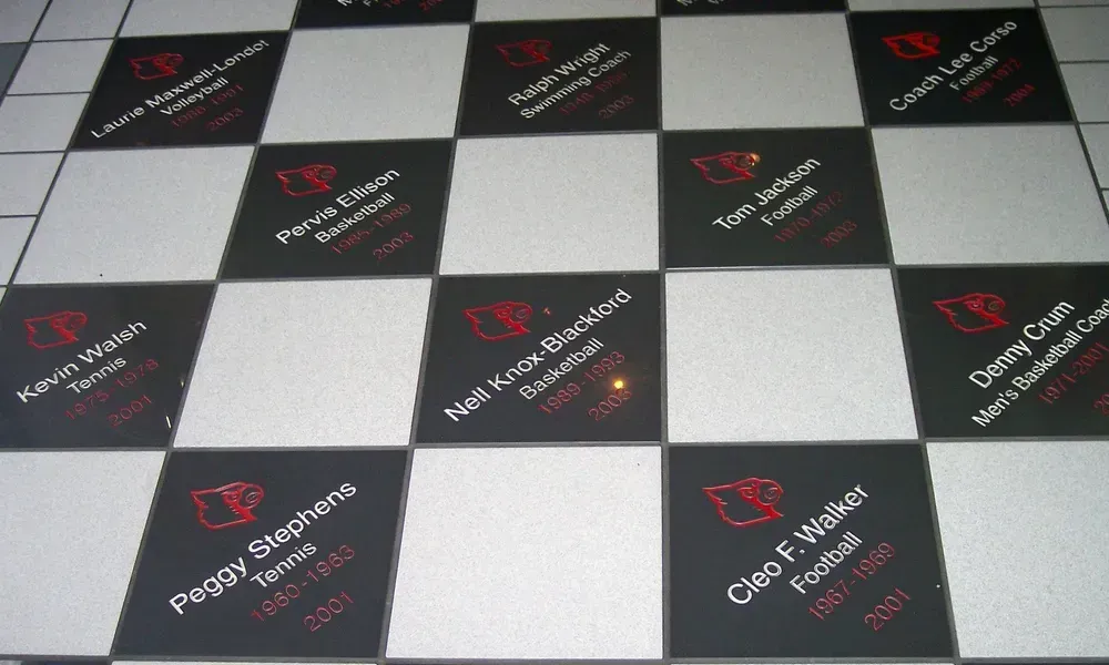 Black-and-white checkered floor with branded tiles and red logos at an event venue