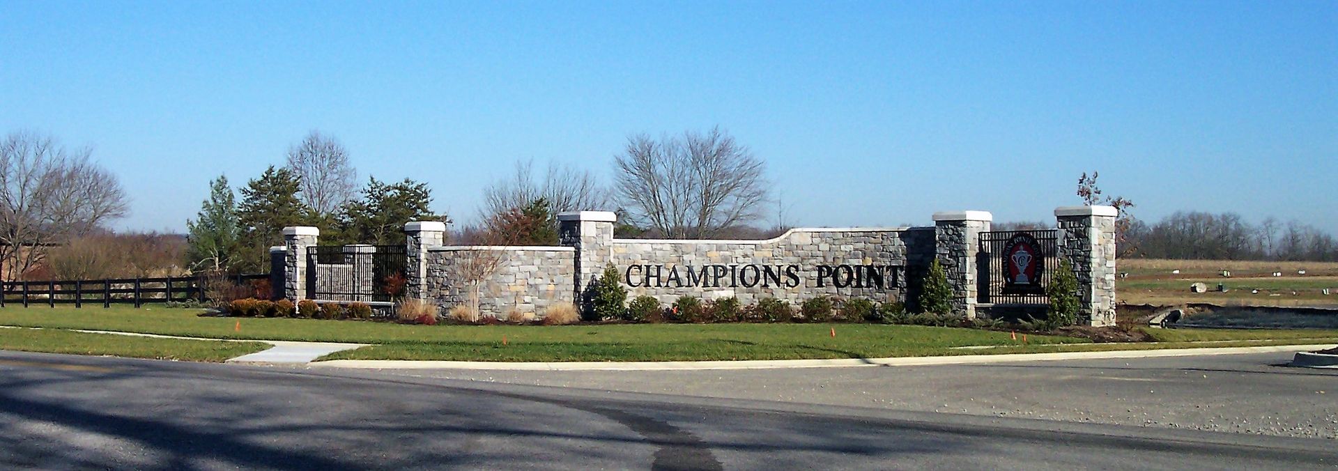 Stone sign entrance to a school campus with trees and a clear blue sky