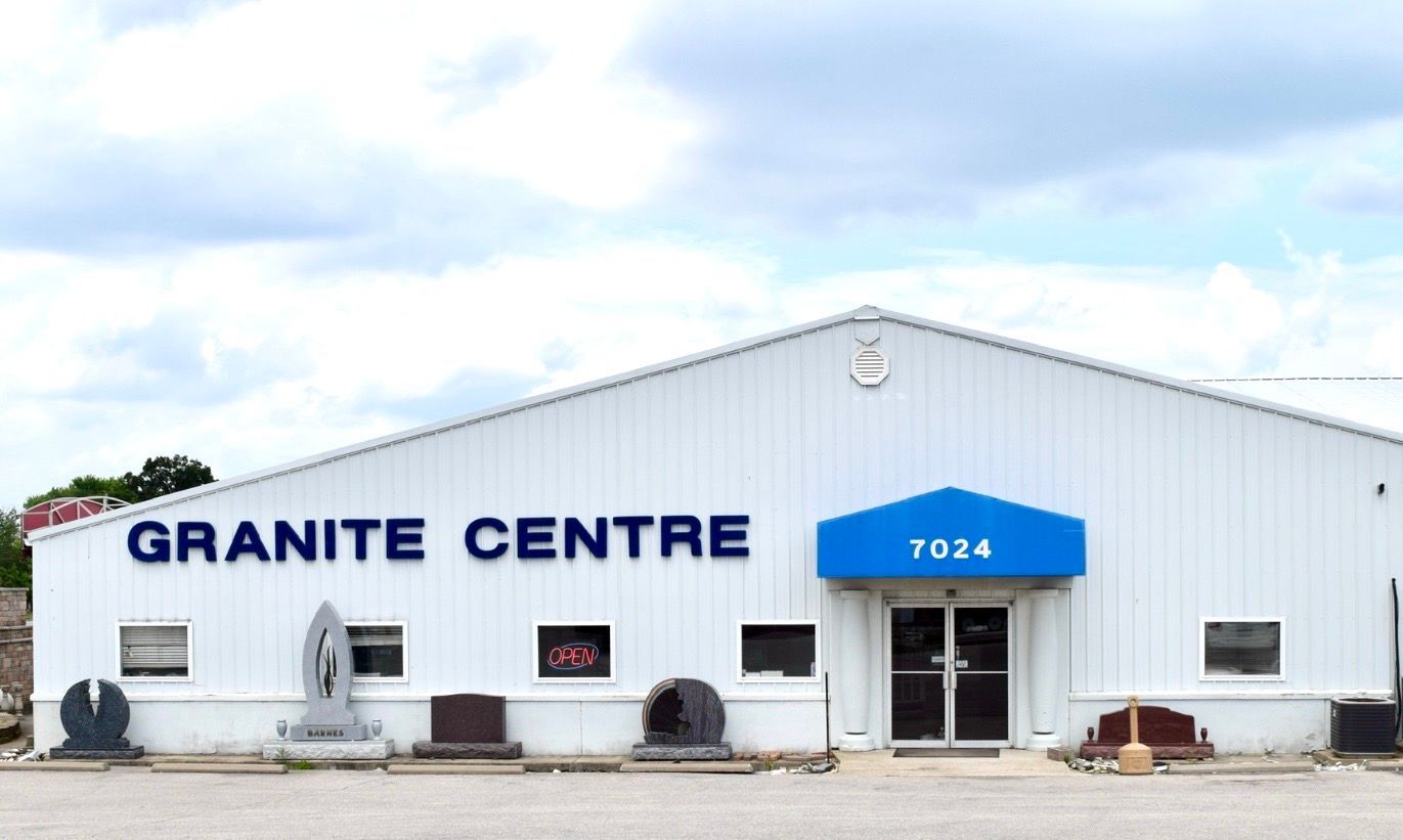 Granite Centre storefront with white siding, blue awning, and address 7024
