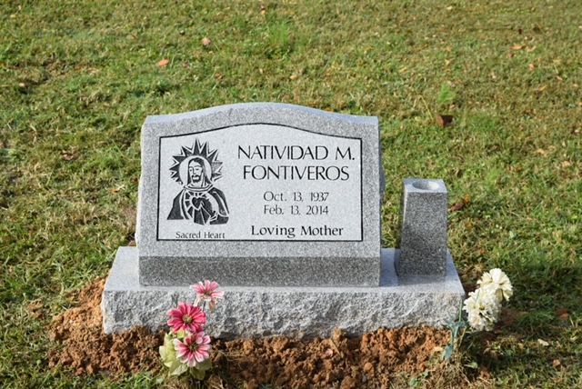 Gray memorial headstone in grass with flowers, engraved “Natividad M. Fontiveros” and “Loving Mother”