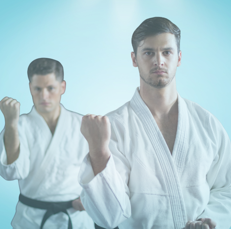 A man in a white karate uniform is standing next to another man in a black belt