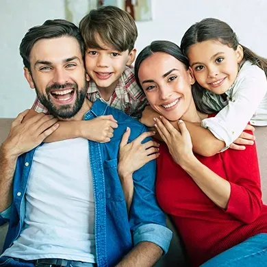 A family is posing for a picture while sitting on a couch.